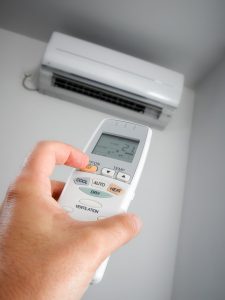 hand-with-remote-turning-on-ductless-air-handler
