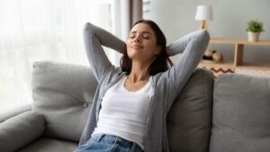 woman-leans-back-on-couch-relaxed